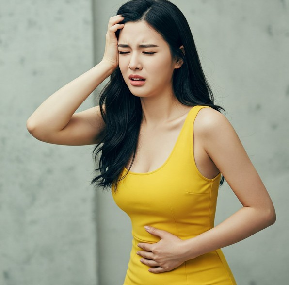 두통과 복통,속이 메스꺼움과 어지러움을 동시에 호소하는 여성